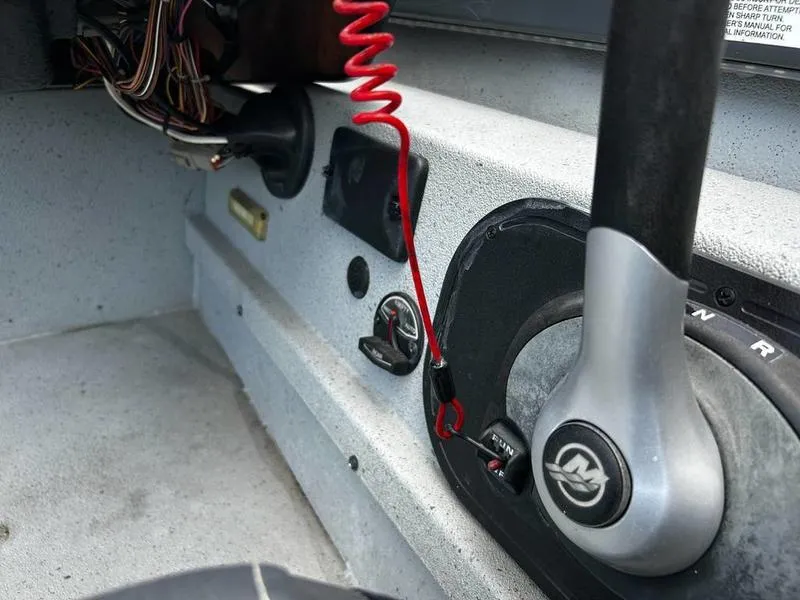 Slide: The Image of 2019 Triton 18 TX boat control panel with throttle and safety lanyard. - 11