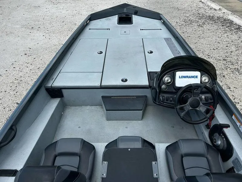 Slide: The Image of 2019 Triton 18 TX boat interior with steering console and seating. - 19