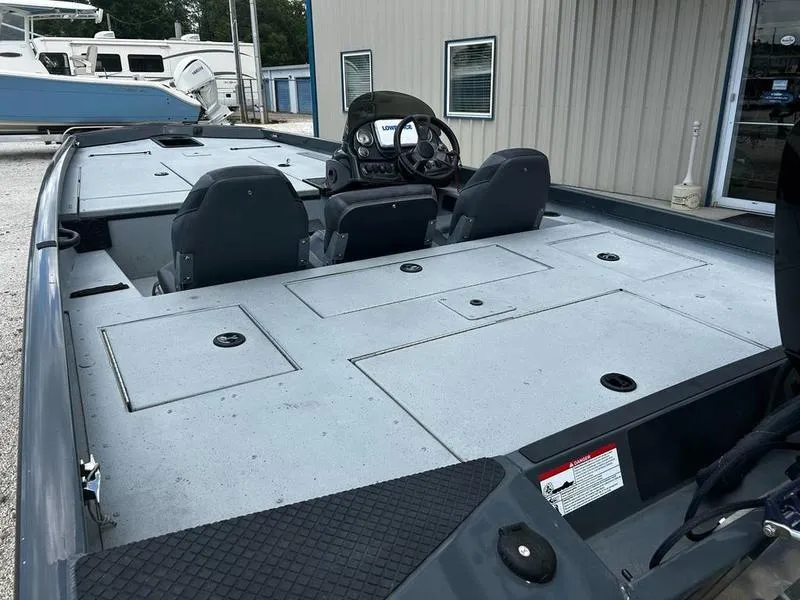 Slide: The Image of 2019 Triton 18 TX boat interior with dual seats and storage compartments. - 21