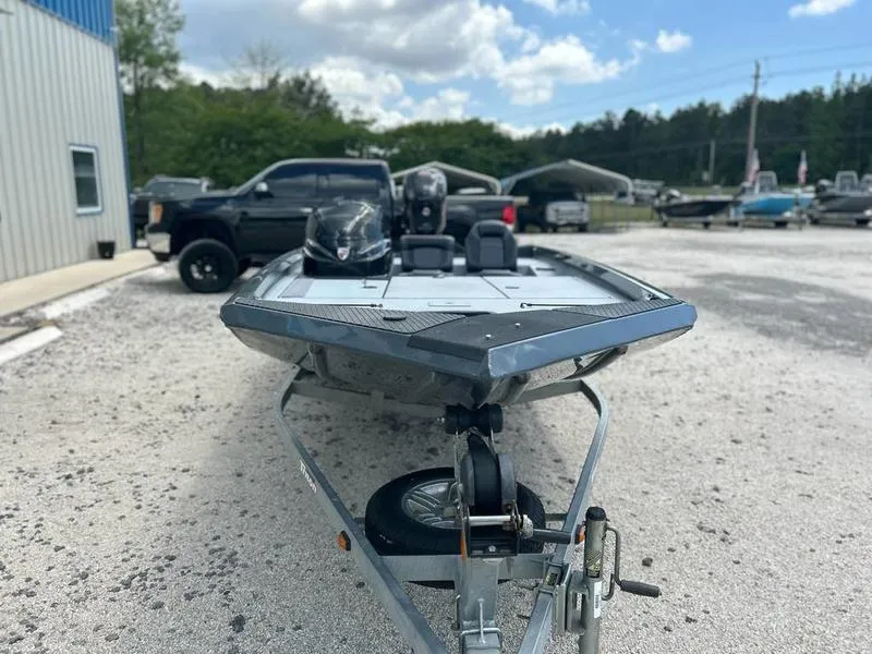 Slide: The Image of 2019 Triton 18 TX boat on trailer in outdoor setting, surrounded by vehicles and trees. - 5