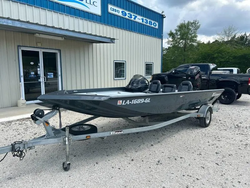 Slide: The Image of 2019 Triton 18 TX boat on trailer parked outside a building. - 7