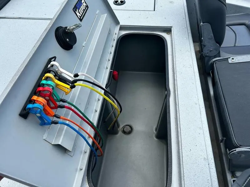 Slide: The Image of 2019 Triton 18 TX boat compartment with organized wiring and storage space. - 8