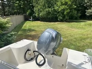 Slide: The Image of 2001 Sea Hunt Triton 200 boat with outboard motor in a grassy yard. - 10