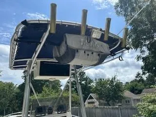 Slide: The Image of 2001 Sea Hunt Triton 200 boat with T-top and rod holders, set against a suburban backdrop. - 3