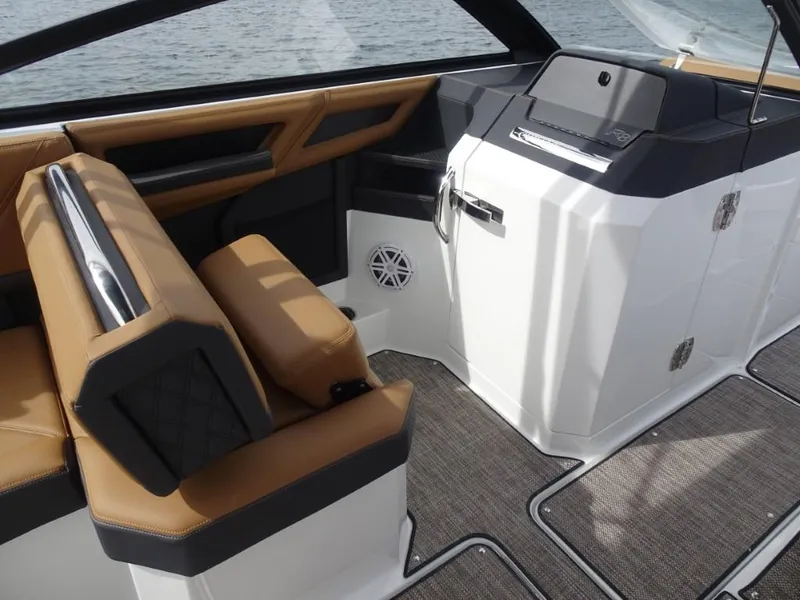 Slide: The Image of 2025 Cobalt R8 boat interior with tan seating, modern dashboard, and sleek design. - 15
