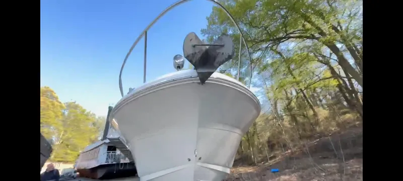 Slide: The Image of 2003 Sea Ray 320 Sundancer boat on land, surrounded by trees, under a clear blue sky. - 10