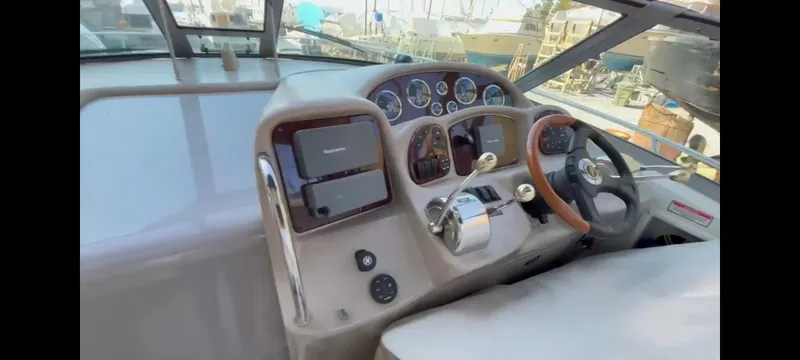 Slide: The Image of 2003 Sea Ray 320 Sundancer helm with gauges, steering wheel, and navigation equipment. - 11