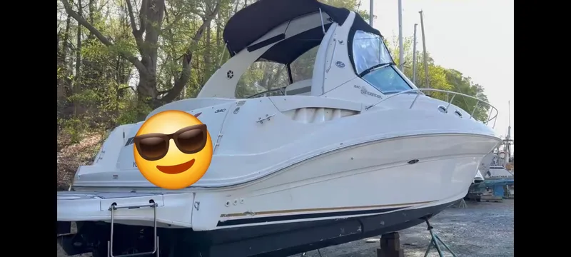 Slide: The Image of 2003 Sea Ray 320 Sundancer boat on land with a black canopy. - 9