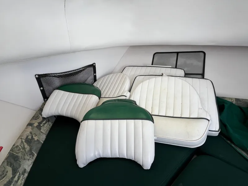Slide: The Image of Cushions from a 2001 Pro-Line 20 WALK boat, featuring white and green upholstery. - 13