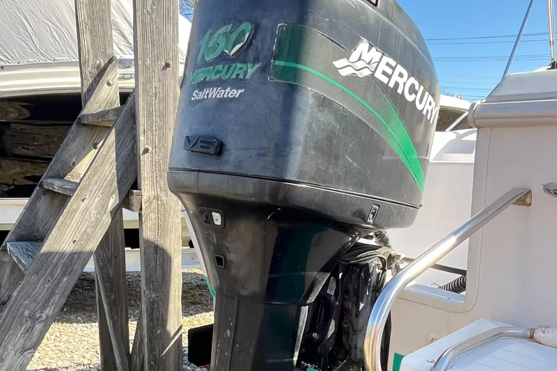 Slide: The Image of Mercury outboard motor on 2001 Pro-Line 20 WALK boat, parked near wooden ladder. - 21