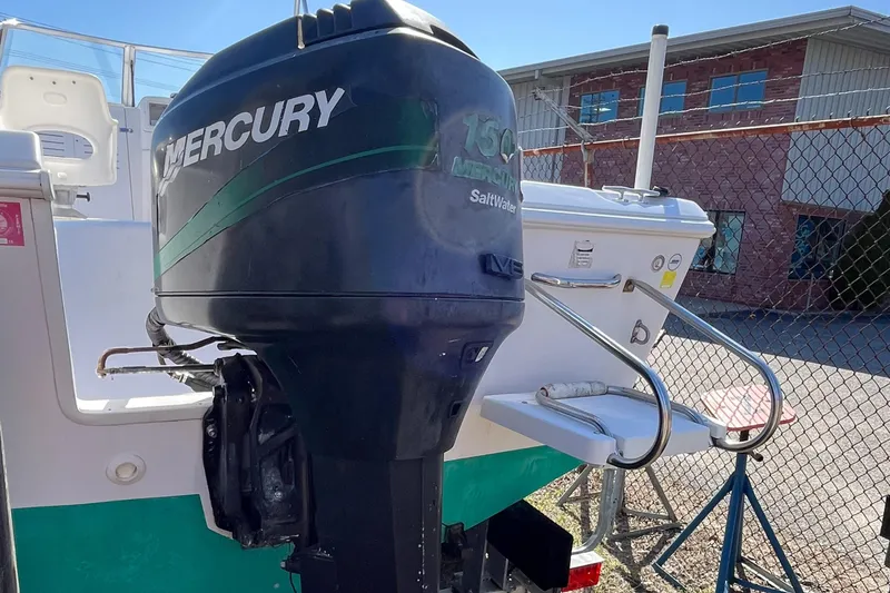 Slide: The Image of 2001 Pro-Line 20 WALK boat with Mercury outboard motor, docked near a fence. - 6