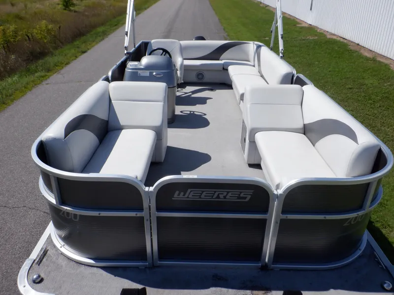 Slide: The Image of 2014 Weeres Cadet Cruise 200 pontoon boat with spacious seating on a sunny day. - 3
