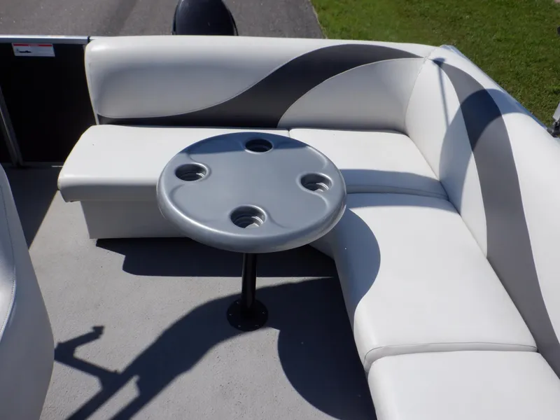 Slide: The Image of 2014 Weeres Cadet Cruise 200 pontoon boat interior with gray seating and round table. - 30