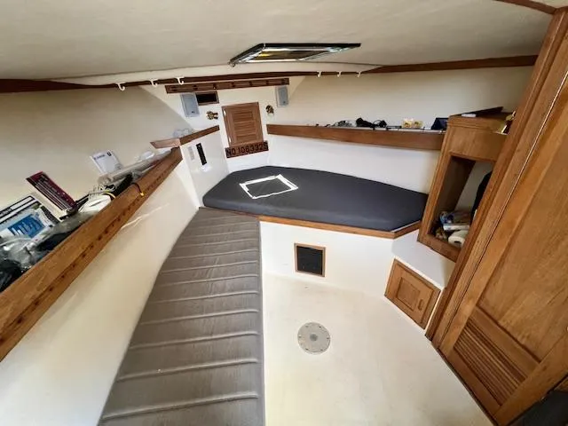 Slide: The Image of 1999 Albemarle 305 Express Fisherman cabin interior with seating, storage, and wooden finishes. - 12