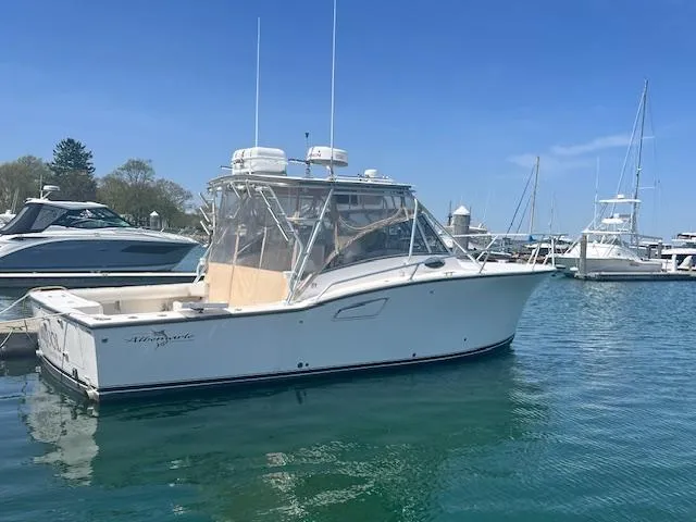 Slide: The Image of 1999 Albemarle 305 Express Fisherman boat docked in a marina under clear blue skies. - 2