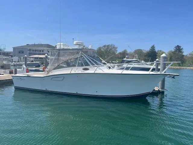 Slide: The Image of 1999 Albemarle 305 Express Fisherman boat docked in a marina under clear blue skies. - 3