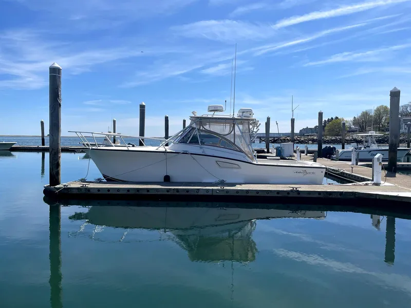 Slide: The Image of 1999 Albemarle 305 Express Fisherman boat docked in a serene marina setting. - 5