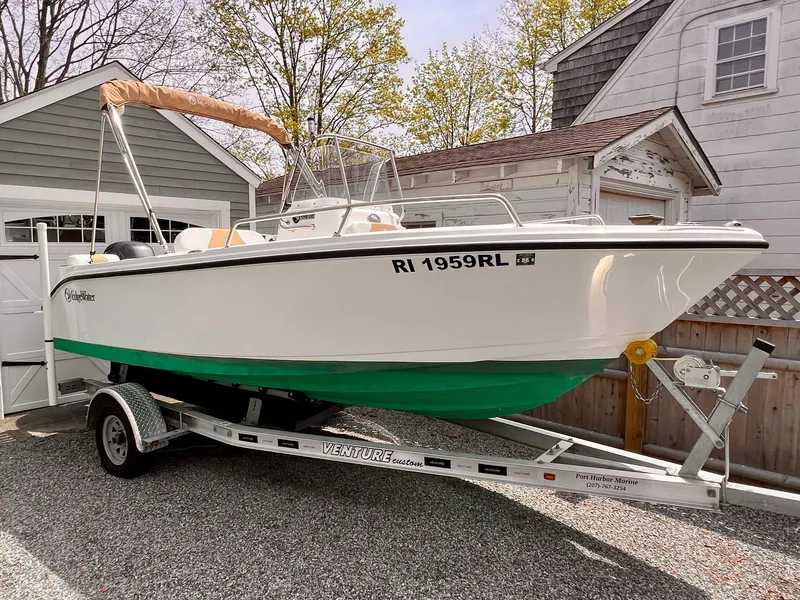 Slide: The Image of 2023 Edgewater 170CC boat on trailer, parked near a house. - 0