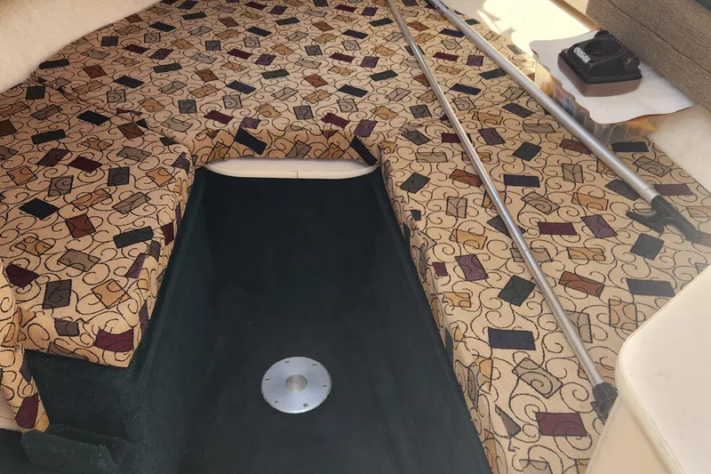 Slide: The Image of 2001 Sea Ray 215 boat interior with patterned upholstery and storage space. - 14