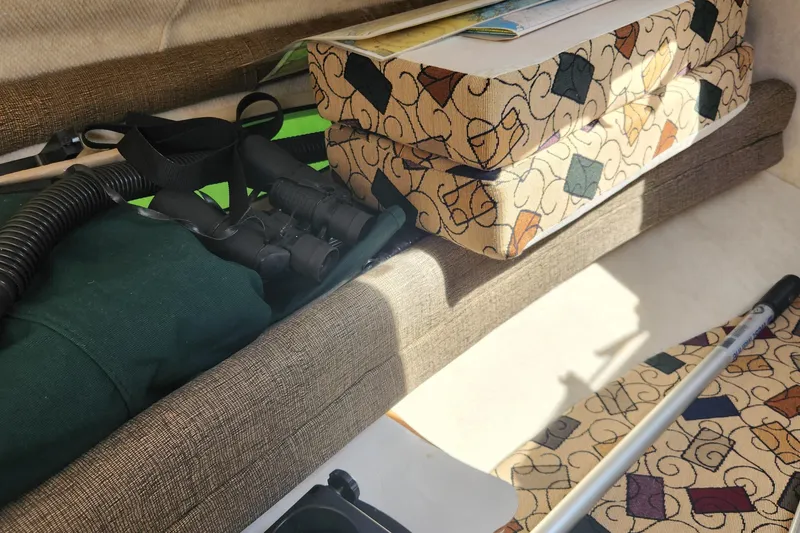 Slide: The Image of Interior of 2001 Sea Ray 215 boat with patterned cushions and boating gear. - 16