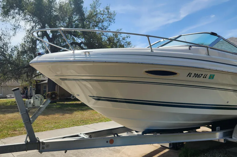Slide: The Image of 2001 Sea Ray 215 boat on trailer, parked outdoors under clear sky. - 4