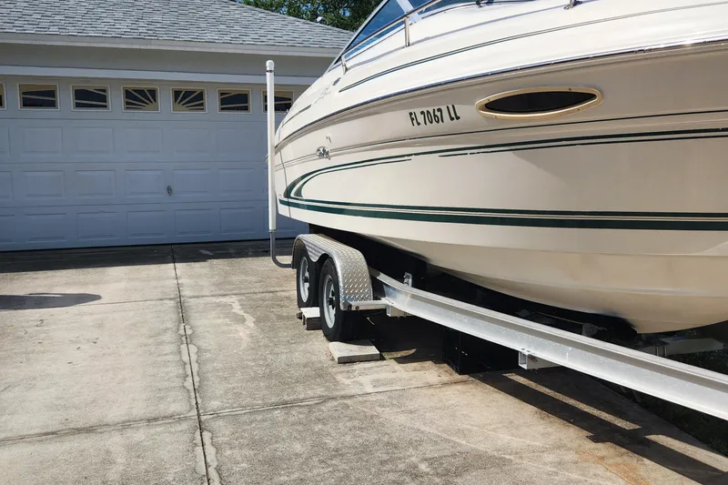 Slide: The Image of 2001 Sea Ray 215 boat on trailer parked in driveway near garage. - 5