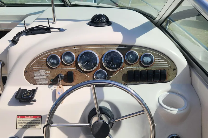 Slide: The Image of 2001 Sea Ray 215 boat dashboard with gauges and steering wheel. - 7