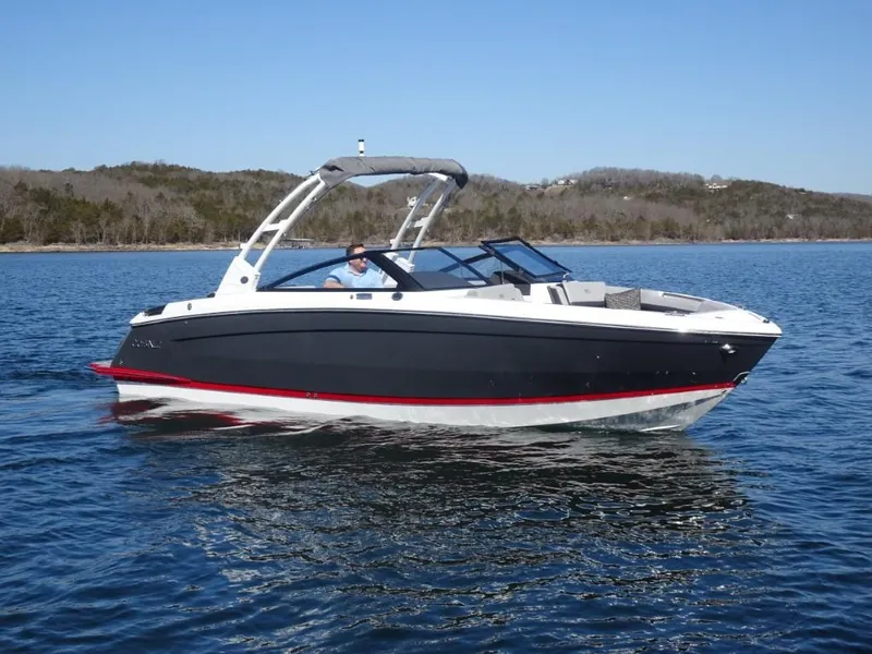 The Image of 2025 Cobalt R8 boat cruising on a serene lake under a clear blue sky. - 0