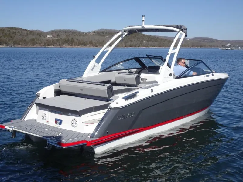 Slide: The Image of 2025 Cobalt R8 boat cruising on a serene lake with scenic hills in the background. - 2