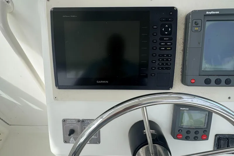 Slide: The Image of Control panel of a 2001 Mako 293 Walkaround boat with Garmin and Raytheon displays. - 10