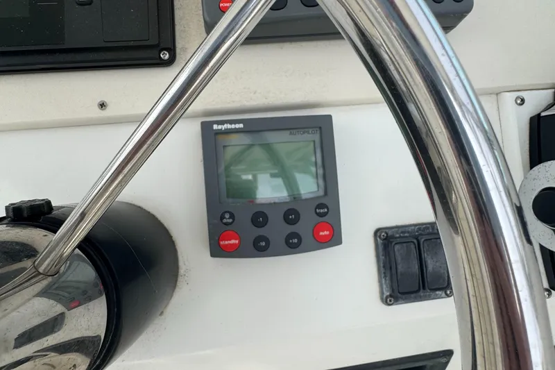 Slide: The Image of Steering wheel and Raytheon autopilot on 2001 Mako 293 Walkaround boat. - 13