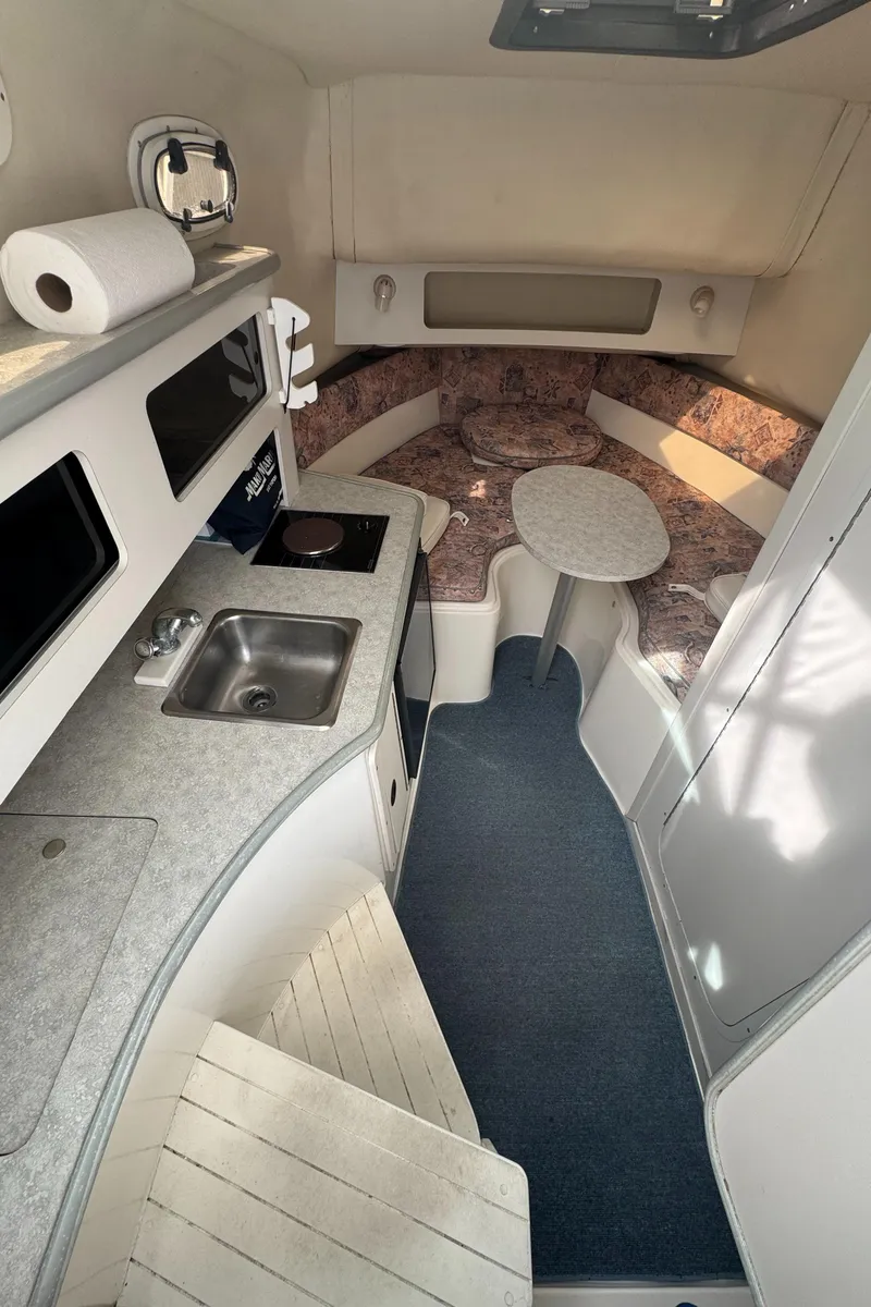 Slide: The Image of Interior of a 2001 Mako 293 Walkaround boat with kitchenette and seating area. - 15