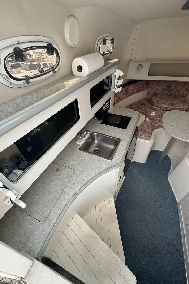 Slide: The Image of 2001 Mako 293 Walkaround boat interior with kitchenette and seating area. - 16