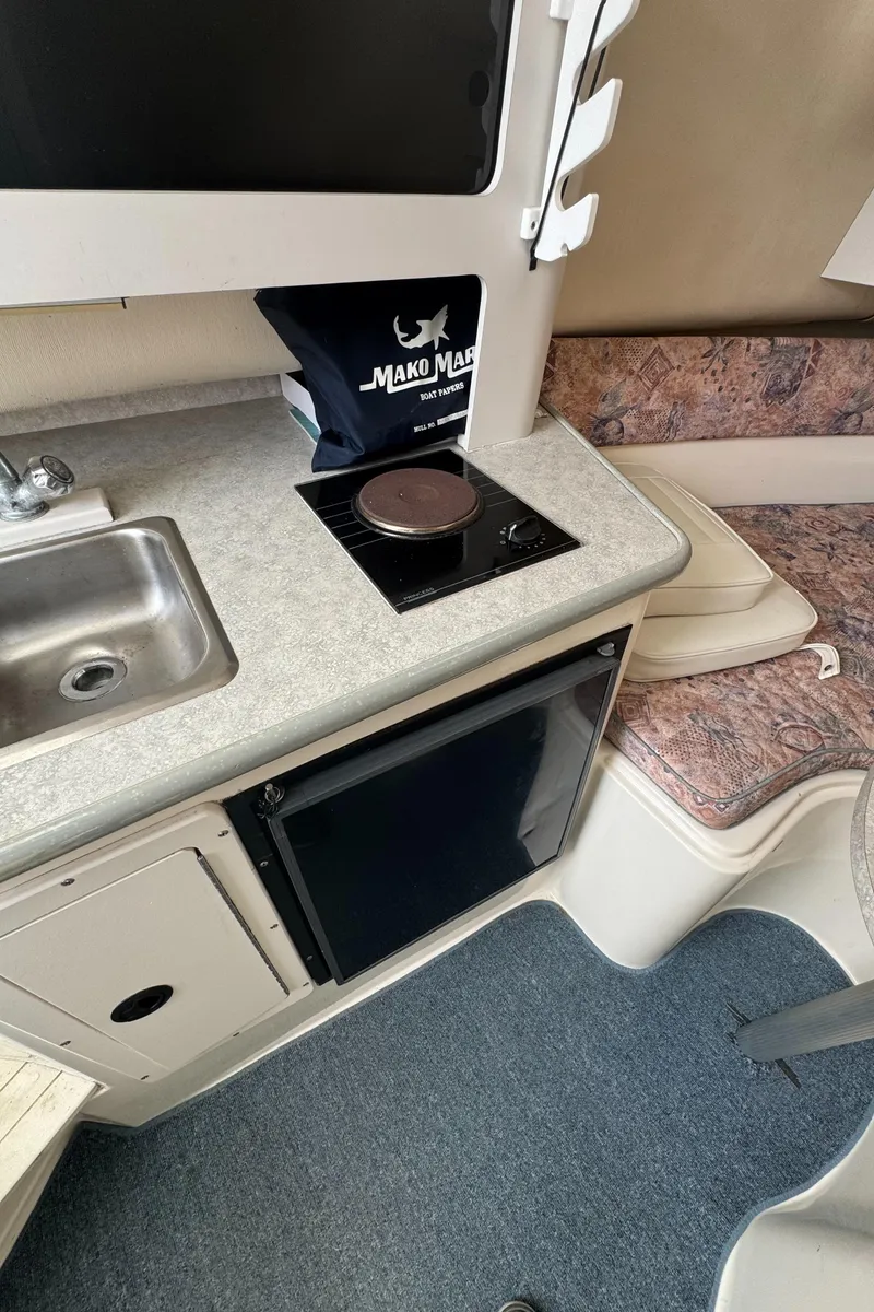 Slide: The Image of 2001 Mako 293 Walkaround boat interior with kitchenette and seating area. - 17