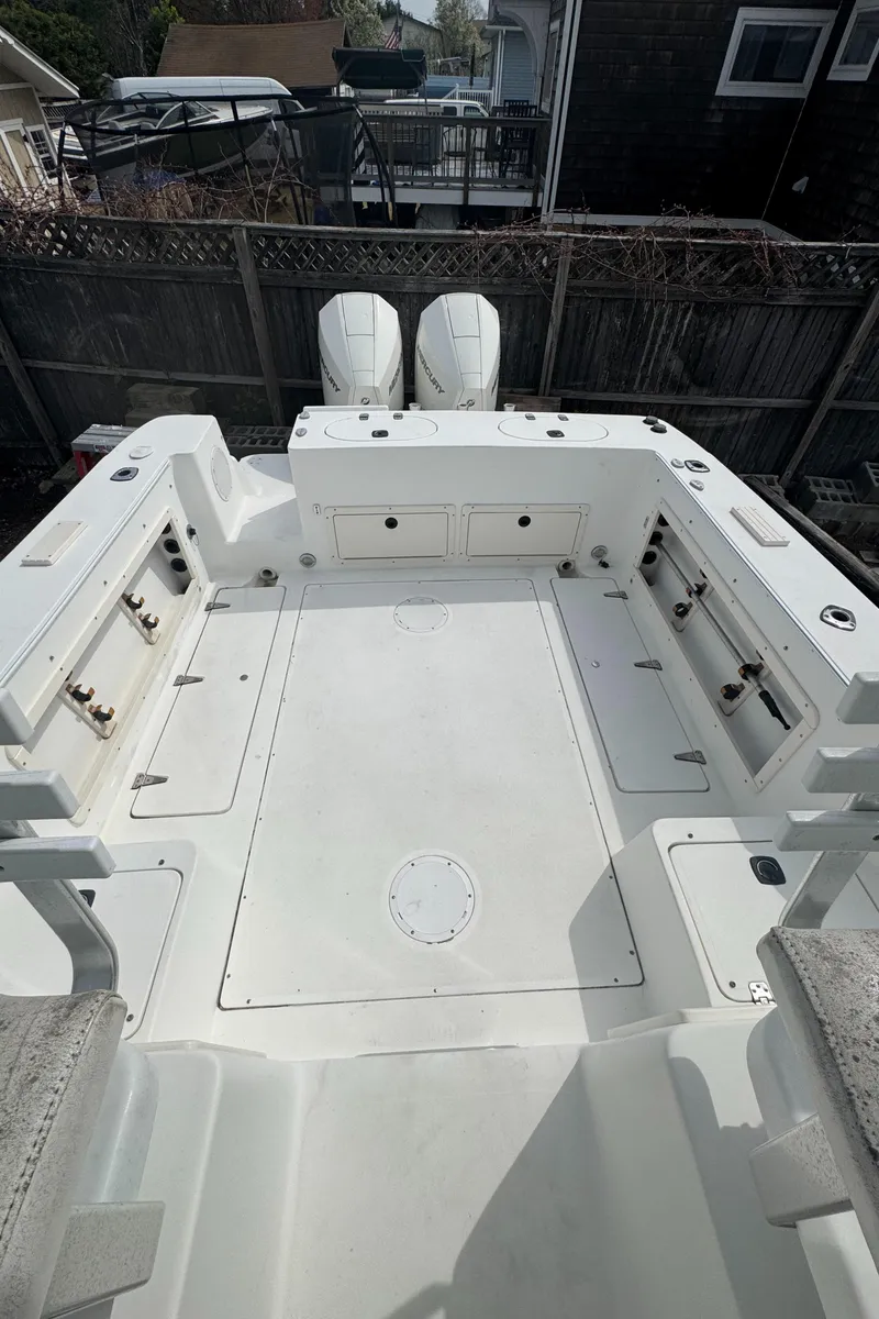 Slide: The Image of 2001 Mako 293 Walkaround boat deck with dual engines, spacious layout, and storage compartments. - 3