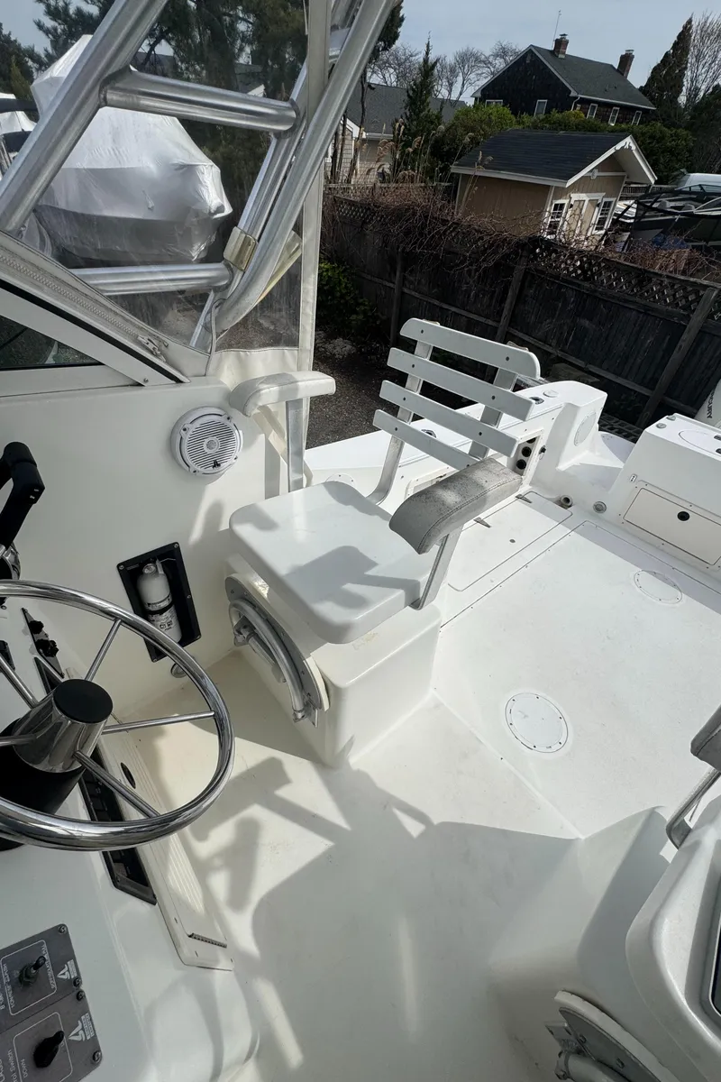 Slide: The Image of 2001 Mako 293 Walkaround boat interior with steering wheel and seating. - 5