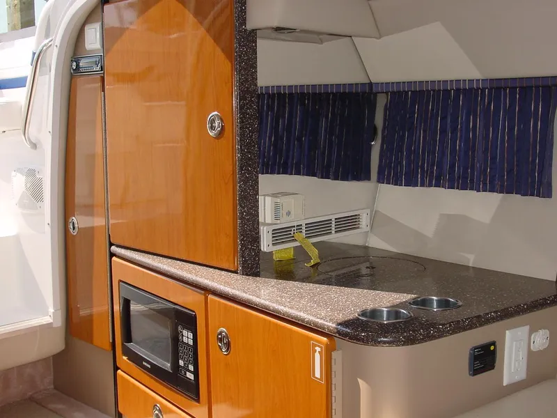 Slide: The Image of Interior of 2004 Formula 330 Sun Sport boat with kitchenette, microwave, and wooden cabinetry. - 10
