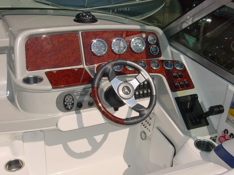 Slide: The Image of Dashboard of a 2004 Formula 330 Sun Sport boat with wood accents and steering wheel. - 13