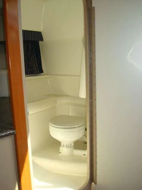 Slide: The Image of 2004 Formula 330 Sun Sport boat bathroom interior with toilet and curtain. - 5