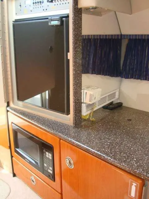 Slide: The Image of 2004 Formula 330 Sun Sport interior with microwave, fridge, and counter space. - 9