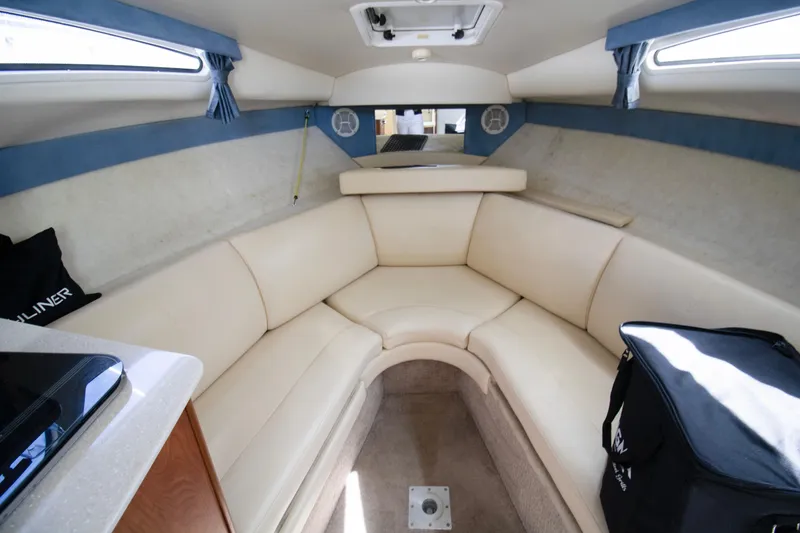 Slide: The Image of Interior of 2007 Bayliner 245 Cierra boat with beige seating and blue accents. - 6