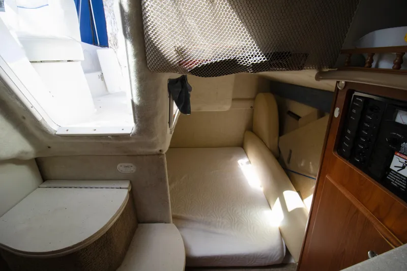 Slide: The Image of 2007 Bayliner 245 Cierra cabin interior with bed, seating, and control panel. - 7