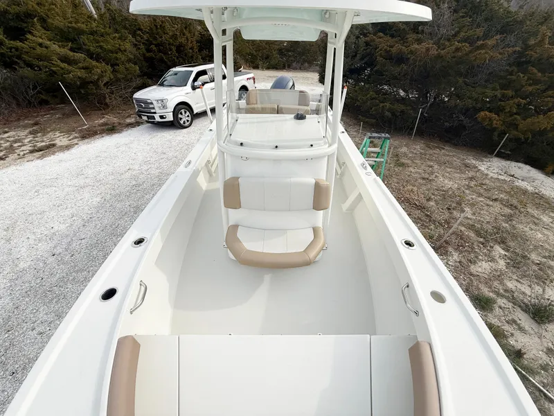 Slide: The Image of 2019 Parker 23 Special Edition boat with seating, parked on gravel near a white truck. - 11