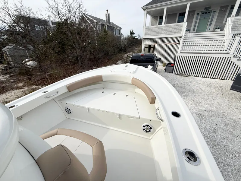 Slide: The Image of 2019 Parker 23 Special Edition boat with beige seating, parked near a coastal house. - 12