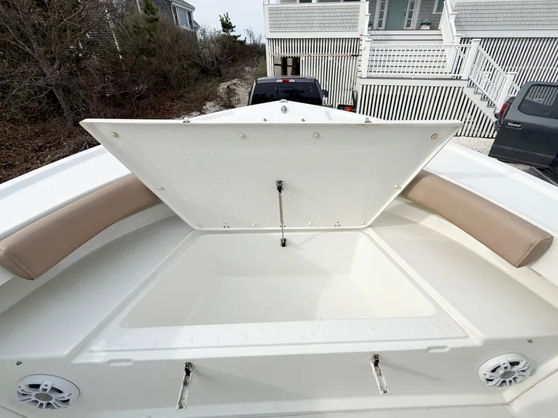 Slide: The Image of 2019 Parker 23 Special Edition boat with open storage compartment and cushioned seating. - 13