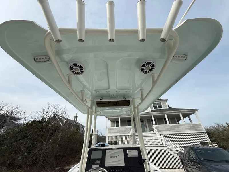 Slide: The Image of 2019 Parker 23 Special Edition boat with T-top and rod holders, parked near a house. - 18
