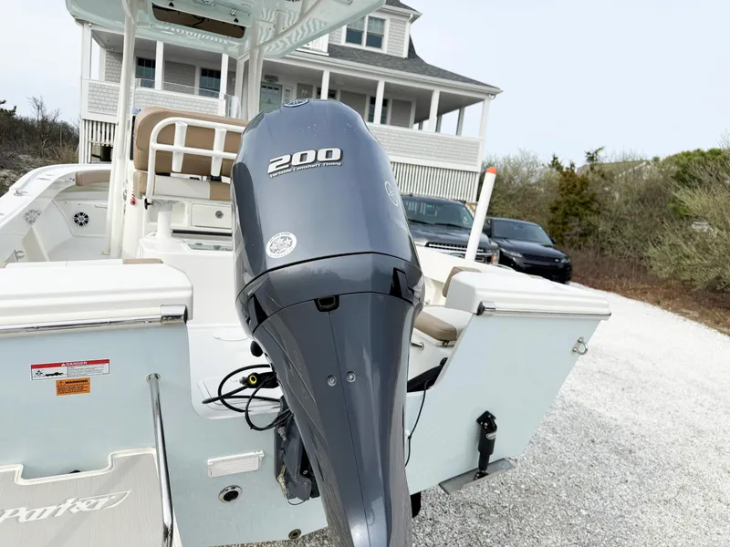 Slide: The Image of Parker 23 Special Edition boat, 2019 model, with powerful 200 horsepower engine, parked near a house. - 2