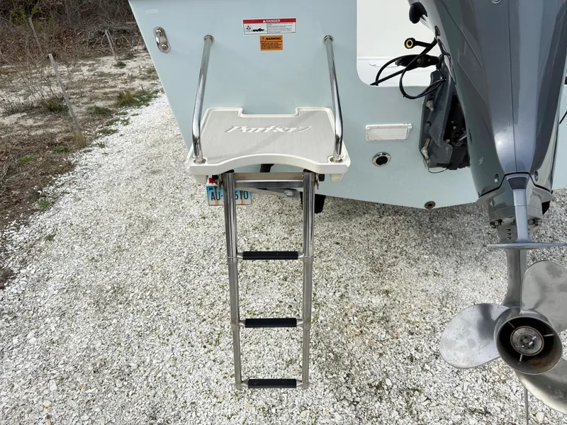 Slide: The Image of Boat ladder on a 2019 Parker 23 Special Edition, gravel background, outboard motor visible. - 3