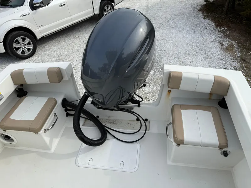 Slide: The Image of 2019 Parker 23 Special Edition boat with outboard motor and seating, parked near a white truck. - 4