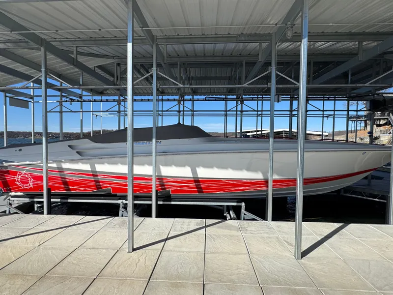 Slide: The Image of 2008 Fountain 38 Lightning boat with red accents docked in a covered marina. - 16